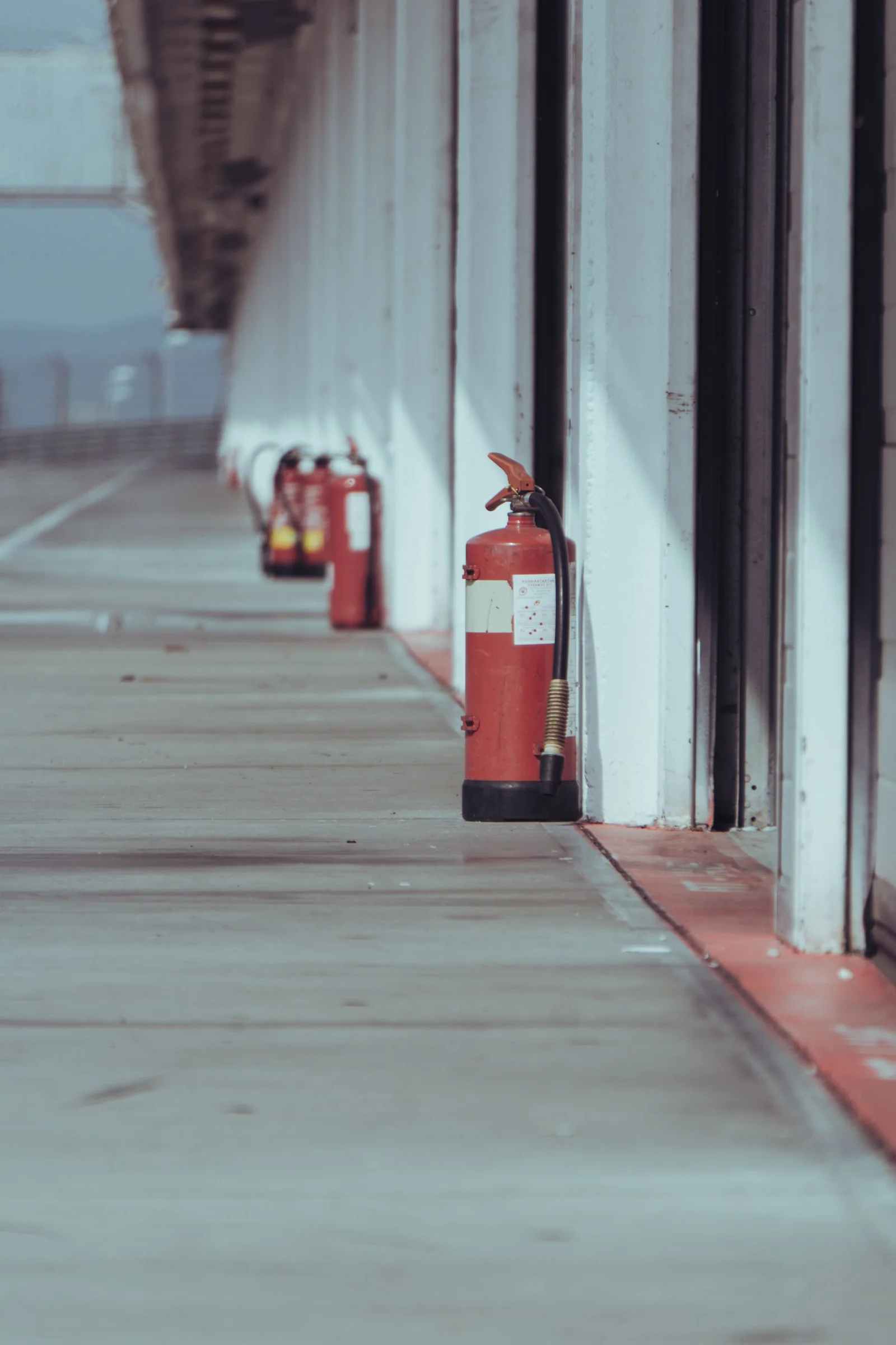 Fire extinguishers positioned along an industrial corridor
