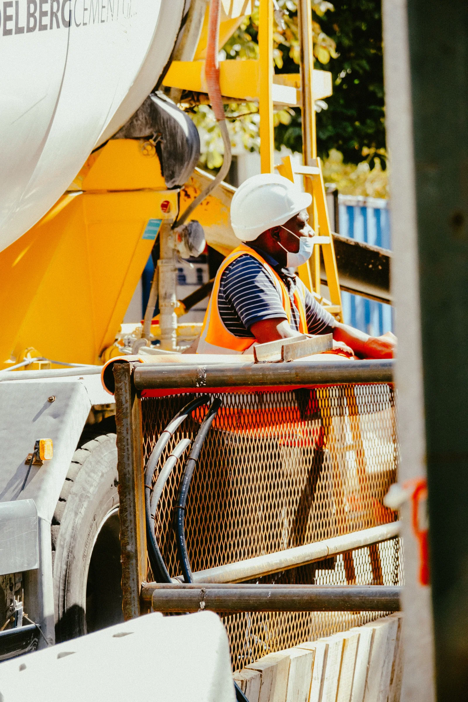 Worker wearing a hard hat and high-visibility vest at an industrial site