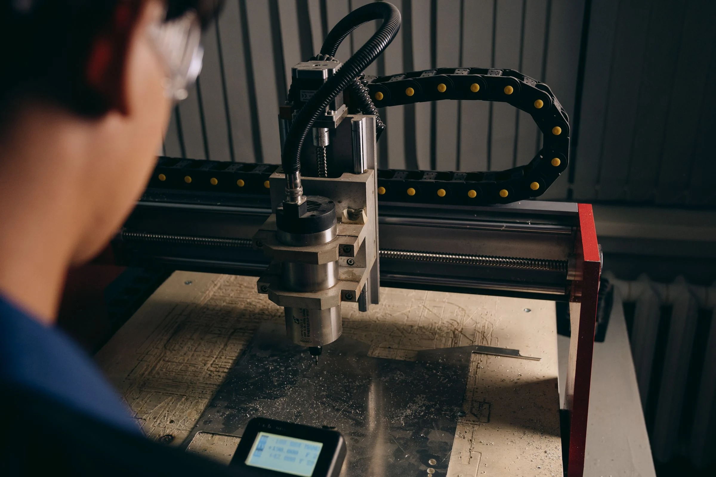 Technician beside a CNC machine in a workshop